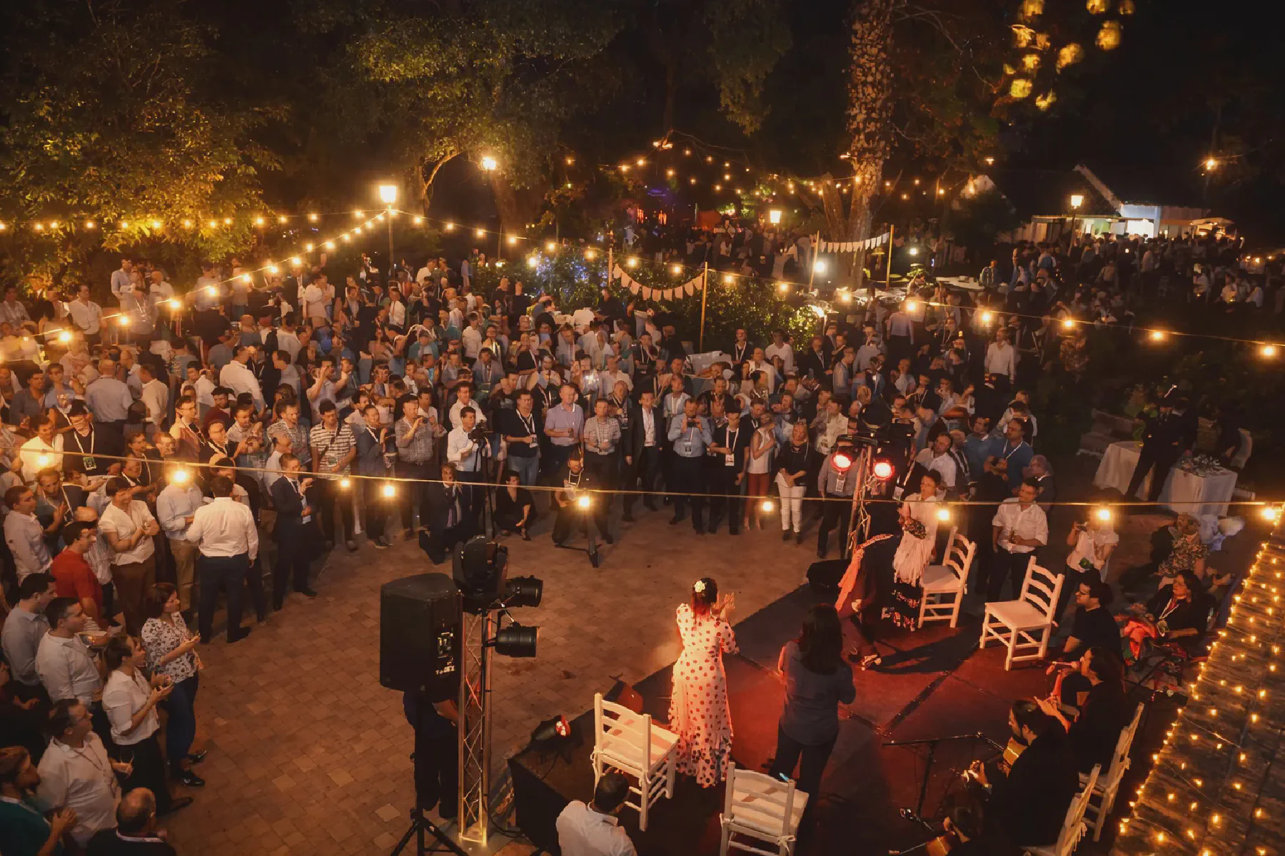 Espectáculo flamenco en directo durante un evento al aire libre con público rodeando el escenario