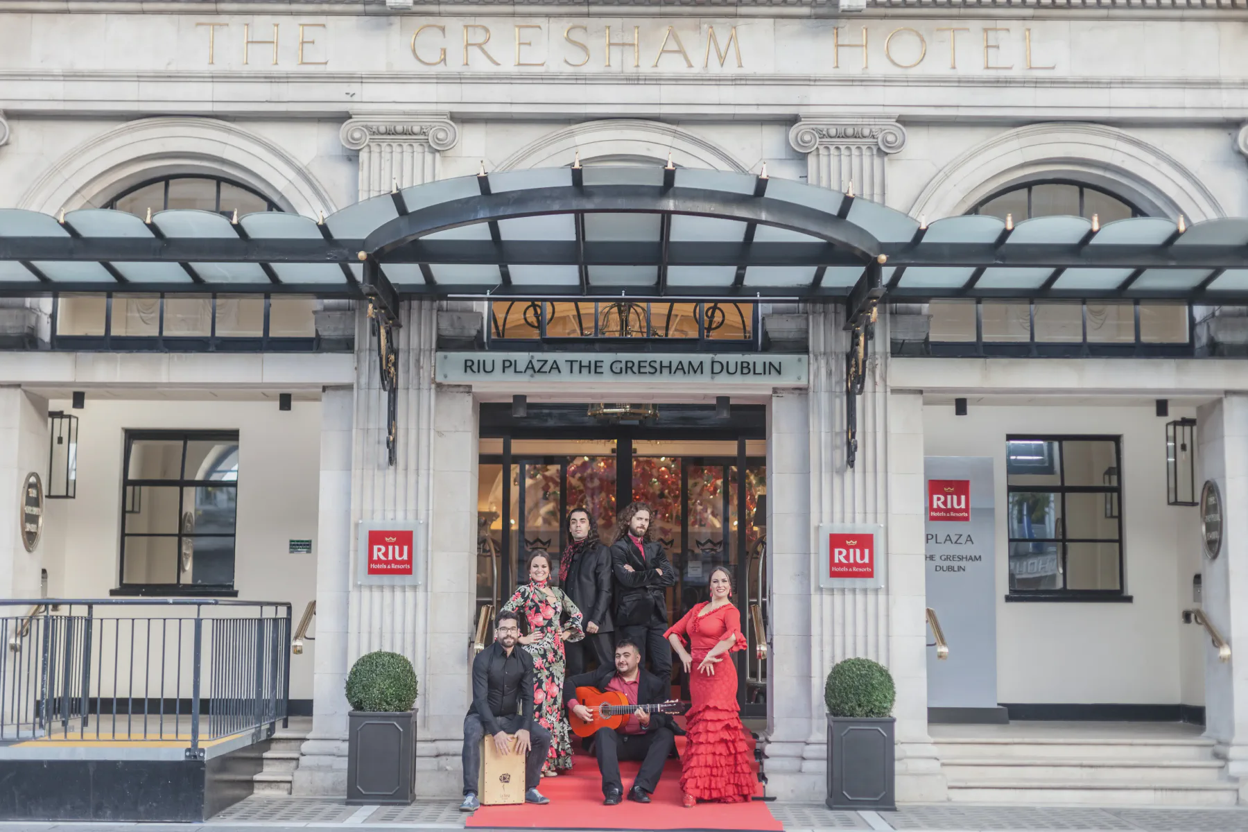 Artistas flamencos posando en la entrada de un hotel de lujo para un espectáculo de evento